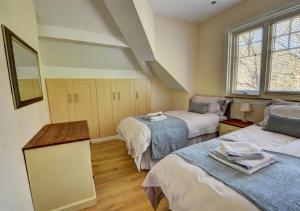 una habitación con tres camas y una ventana en Aberlyn, en Lynmouth