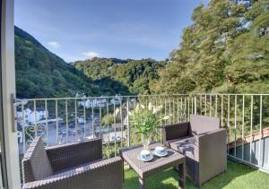 a balcony with two chairs and a table with a view at Aberlyn in Lynmouth