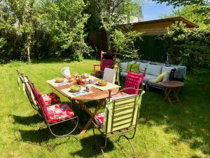 a wooden table and chairs in a yard at Superbe studio privé in Thionville