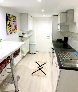 a kitchen with white cabinets and black counter tops at Superbe studio privé in Thionville