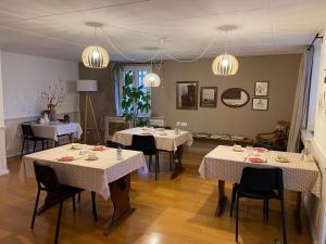 uma sala de jantar com mesas, cadeiras e lustres em Les Suites - La Cour St Fulrad em Saint-Hippolyte