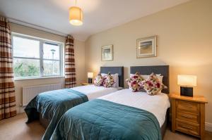 two beds in a bedroom with a window at Foleys Ardmullen Townhouses in Kenmare