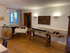 Habitación con mesa de madera y barril de vino. en Les Suites - La Cour St Fulrad en Saint-Hippolyte