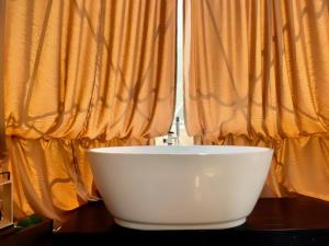 eine weiße Schüssel auf einem Tisch vor einem Fenster in der Unterkunft זריחת הירדן בכנרת - סוויטות יוקרה in Poriyya