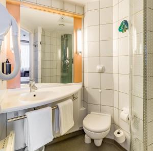 W łazience znajduje się umywalka toaletowa i lustro. w obiekcie Ibis Warszawa Reduta w Warszawie