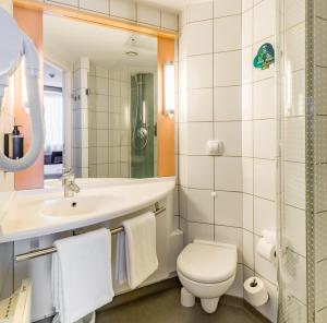 y baño con lavabo y espejo. en Ibis Warszawa Reduta, en Varsovia