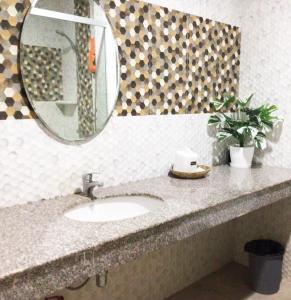 een badkamerbar met een wastafel en een spiegel bij Say Rose Homestay 