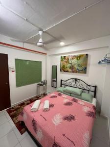 1 dormitorio con cama rosa y pantalla verde en MyDusun Chalet, Taiping, Perak, Malaysia en Taiping