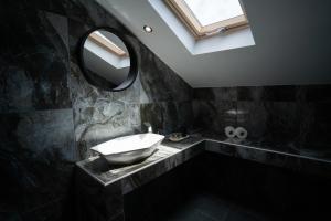 a black bathroom with a sink and a mirror at Parthenis Riviera Hotel in Athens +37 photos