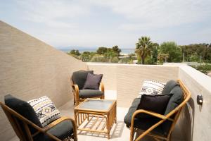a patio with chairs and a table on a balcony at Parthenis Riviera Hotel in Athens