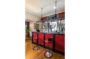um bar com armários vermelhos e bancos num quarto em Orestone Manor em Torquay