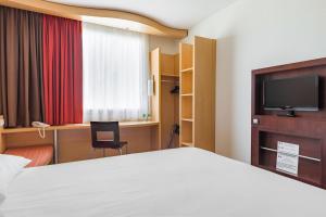 ワルシャワにあるibis Warszawa West Stationのベッドとテレビがあるホテルの部屋