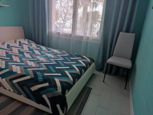 a bedroom with a bed and a chair and a window at Detached house with garden and sea view in Sanremo
