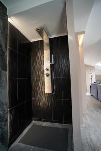 a bathroom with a shower with black tiles at Parthenis Riviera Hotel in Athens