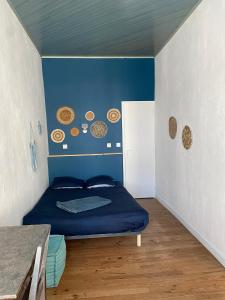 een kamer met een bed met een blauwe muur bij Maison de casteljaloux 9 personnes in Casteljaloux