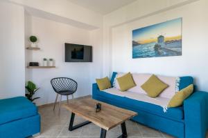 a living room with a blue couch and a table at Zandre shiny apartment in Nea Potidaea