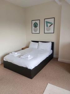 a bedroom with a bed with white sheets and pillows at Views over the Peak District Apartment with WIFI in Sheffield