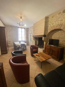 een woonkamer met banken en een stenen open haard bij Maison de casteljaloux 9 personnes in Casteljaloux