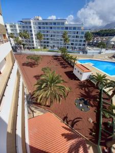 widok na ośrodek z basenem i palmami w obiekcie Apartamento Vacacional Playa w Playa de las Americas