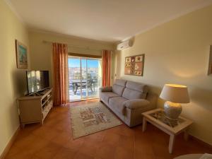 een woonkamer met een bank en een televisie bij Condomínio do Mar in Lagos