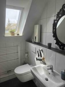 a bathroom with a toilet and a sink and a mirror at Haus 6 Pers mit Garten 15 min zur Messe Düsseldorf in Krefeld