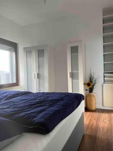 1 dormitorio con cama con sábanas azules y ventana en Haus 6 Pers mit Garten 15 min zur Messe Düsseldorf, en Krefeld