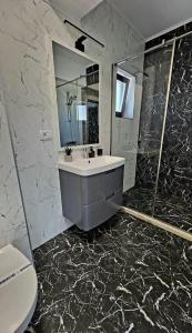 a bathroom with a sink and a mirror at Sofi Residence Promenada in Mamaia Nord