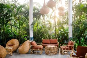 a patio with rattan chairs and a couch and tables at Panta Rei resort in Ahangama