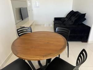 una mesa y sillas en una sala de estar con sofá en Conceito Saúde, Orthomed, Cot, UMC, VEM PRA CA!, en Uberlândia