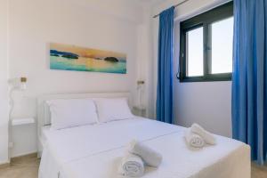 a bedroom with a white bed with towels on it at Zandre shiny apartment in Nea Potidaea