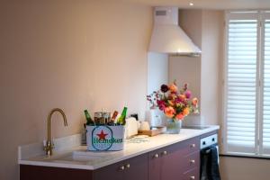 a kitchen counter with a sink and a vase of flowers at Craig Walk Suite in Bowness-on-Windermere