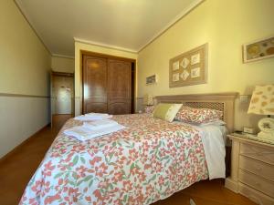 een slaapkamer met een bed met een bloemenbed bij Condomínio do Mar in Lagos +22 foto's