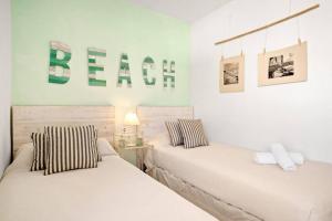 two beds in a bedroom with a sign on the wall at Can Palanca in Cala Llonga