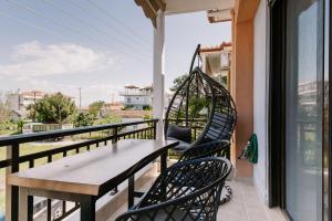 a patio with a table and chairs on a balcony at Zandre shiny apartment in Nea Potidaea