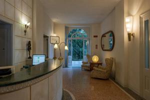 a lobby with a counter and a living room at Hotel Milano in Toscolano Maderno