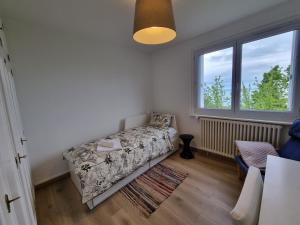 a bedroom with a bed and a window at Vue Lac, Central et Contemporain in Évian-les-Bains