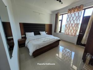 a bedroom with a bed and two windows at Peaceful Dalhousie in Dalhousie