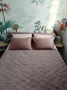 a bed with pink pillows in a bedroom with plants at Boutique apartment Alla Dolce Vita in Vicenza