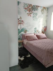 a bedroom with a bed with pink sheets and tropical wallpaper at Boutique apartment Alla Dolce Vita in Vicenza