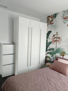 a bedroom with white cabinets and a pink bed at Boutique apartment Alla Dolce Vita in Vicenza +16 photos