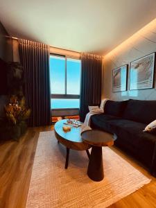 uma sala de estar com um sofá e uma mesa em Carmel Holiday Apartments em Netanya