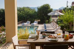 drewniany stół z jedzeniem na patio z basenem w obiekcie Serene villa Meganisi - Seaview & Exclusive Pool w mieście Meganisi