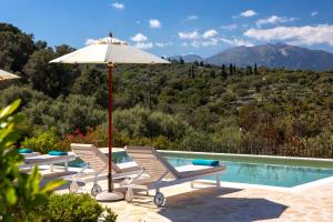 dwa krzesła i parasol obok basenu w obiekcie Serene villa Meganisi - Seaview & Exclusive Pool w mieście Meganisi