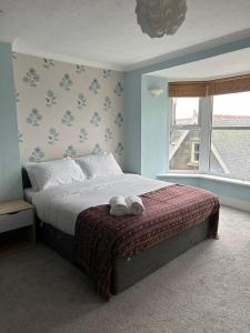 a bedroom with a bed with two towels on it at Bronallt in Barmouth