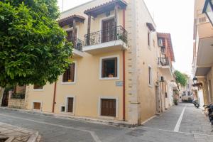 un bâtiment jaune au bord d'une rue dans l'établissement Mat Old Town Apartments B, à Réthymnon