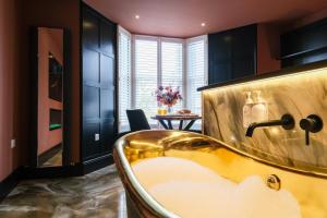 a bath tub in a room with a table at Craig Walk Suite in Bowness-on-Windermere