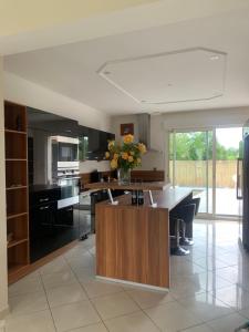 una cocina con una mesa con un jarrón de flores. en Villa avec piscine aux portes du circuit des 24 heures, en Arnage