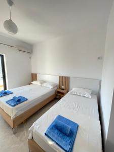 two beds in a room with two blue towels at Villa Soni Oruci in Ksamil