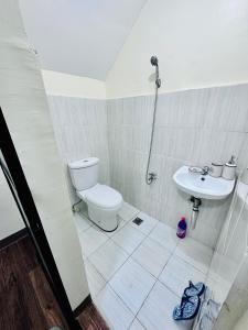 y baño con aseo y lavamanos. en 3 bedroom house Prestige Cabantian near Malls and Airport, en Davao City