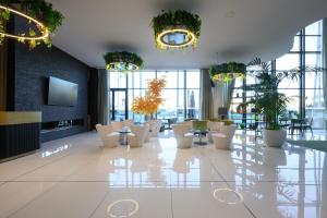 a lobby with white chairs and tables and windows at Melia Braga Hotel & Spa in Braga